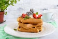 Whole wheat Belgian waffles with whipped cream, freshly chopped strawberries, mint leaves and chocolate and a cup of tea Royalty Free Stock Photo