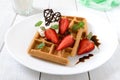 Whole wheat Belgian waffles with whipped cream, freshly chopped strawberries, mint leaves and chocolate Royalty Free Stock Photo