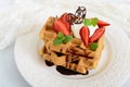 Whole wheat Belgian waffles with whipped cream, freshly chopped strawberries, mint leaves Royalty Free Stock Photo