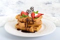 Whole wheat Belgian waffles with whipped cream, freshly chopped strawberries, mint leaves Royalty Free Stock Photo