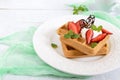 Whole wheat Belgian waffles with whipped cream, freshly chopped strawberries, mint leaves Royalty Free Stock Photo