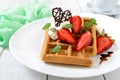 Whole wheat Belgian waffles with whipped cream, freshly chopped strawberries, mint leaves Royalty Free Stock Photo