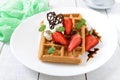 Whole wheat Belgian waffles with whipped cream, freshly chopped strawberries, mint leaves Royalty Free Stock Photo