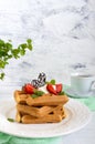 Whole wheat Belgian waffles with whipped cream, freshly chopped strawberries, mint leaves Royalty Free Stock Photo
