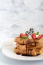 Whole wheat Belgian waffles with whipped cream, freshly chopped strawberries, mint leaves Royalty Free Stock Photo