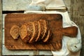 Whole wheat bread cut in slices on a wooden board at home Royalty Free Stock Photo