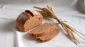 Whole wheat bread loaf paired with wheat stalks on a clean white backdrop Royalty Free Stock Photo