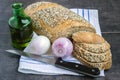 Whole wheat bread and rye, sprinkled with sunflower seeds, poppy seeds, sesame seeds, on a napkin, next to the onion and olive oil