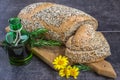 Whole wheat bread and rye, sprinkled with sunflower seeds, poppy seeds, sesame seeds, sliced on the board, next to a jar of olive