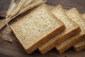 Whole wheat bread slices and wheat on wooden table Royalty Free Stock Photo