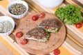 A healthy meal of whole wheat dark brown rye bread, curd cream cheese, radish, alfalfa sprouts, ham, cherry tomatoes, salad. Royalty Free Stock Photo
