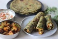 Whole wheat methi thepla rolls with paneer capsicum filling and a bowl of masala curd