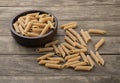 Whole wheat penne pasta on a bowl over wooden table Royalty Free Stock Photo