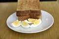 Whole wheat slice toasted bread with sliced boiled egg on the white plate for breakfast Royalty Free Stock Photo