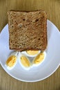 Whole wheat slice toasted bread with sliced boiled egg on the white plate for breakfast Royalty Free Stock Photo