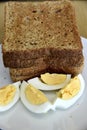 Whole wheat slice toasted bread with sliced boiled egg on the white plate for breakfast Royalty Free Stock Photo