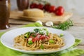 whole wheat spaghetti pasta with fresh tomato sauce, fried spring onions and parmesan served on a rustic wooden table, some Royalty Free Stock Photo