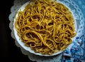 Whole wheat spaghetti in a white plate on a dark brown table Royalty Free Stock Photo