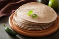 Whole wheat tortillas on wooden board and vegetables