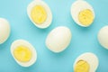 Whole white egg and halved boiled egg with yolk on blue background Royalty Free Stock Photo