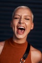 The whole worlds gotta hear how happy she is. an attractive young woman screaming while standing against a dark Royalty Free Stock Photo