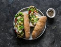 Wholegrain buns sandwiches with grilled eggplant, tomatoes, ham, mozzarella and micro-greens on a dark background, top view