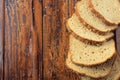 Wholegrain sliced organic bread composed of oats and flax seeds on wooden table. Copy space