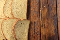 Wholegrain sliced organic bread composed of oats and flax seeds on wooden table. Copy space