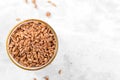 Wholegrain uncooked raw spelt farro in ceramic bowl on grey stone table