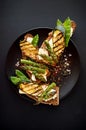 Wholemeal bread sandwiches with feta cheese, grilled zucchini, green asparagus, sugar peas, olive oil on a black background Royalty Free Stock Photo