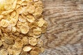 Wholemeal Cornflakes close-up on wooden background with copy space, useful breakfast whole grain corn flakes, flat lay