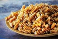 Wholemeal Fusilli in a plate. Integral Pasta over a wooden table