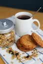 Wholemeal oatmeal cookies stack with granola and tea on napkin