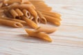 Wholemeal penne Rigate, healthy pasta alternative from whole grain durum wheat on a light wooden table, copy space, selected focus Royalty Free Stock Photo