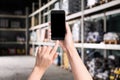 Wholesale trading. Woman using WMS app on smartphone at warehouse Royalty Free Stock Photo