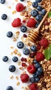 Wholesome american breakfast granola, milk, berries, honey on white background with copy space.