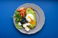 Wholesome tasty full of vitamins and health breakfast with avocado, berries, cheese and tomatoes with basil.