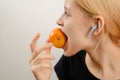 Wholesome teenage treat: A slim young woman enjoys the goodness of a ripe yellow plum, savoring the wholesome delight of