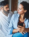 Whos number is this. a dismayed couple receiving bad news via a smartphone at home. Royalty Free Stock Photo