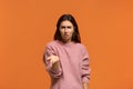 Why did you do that. Portrait of Indignant shocked beautiful woman in pink sweater keeps palm raised, cant understand something,