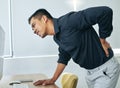 Why does my back have to age first. a handsome young businessman standing alone in his office and suffering from back Royalty Free Stock Photo