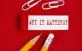 WHY IT MATTERS written on torn red paper with pencils and clips, business
