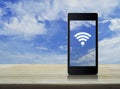 Wi-fi connection icon on modern smart phone screen on wooden tab Royalty Free Stock Photo