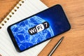 Wi-Fi 7 generation background, icon close-up. Smartphone supporting new Wi-Fi technology for communication, business