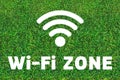 Wi-Fi zone. Free internet point in a bar, restaurant, cafe or park. Wi-Fi icon on a green grass background. Technology Royalty Free Stock Photo