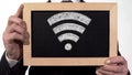 Wi-Fi zone sign drawn on blackboard in businessman hands, internet technology