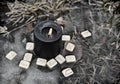 Wiccan ritual with wooden runes and black candle in the water