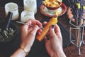 Wiccan witch carving symbols and sigils onto yellow gold color candlestick at her altar