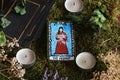 Wiccan witch holding a small hand painted made up Hermit tarot card in her hands