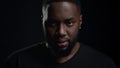 Wicked afro guy screaming on black background. Closeup man yelling in studio